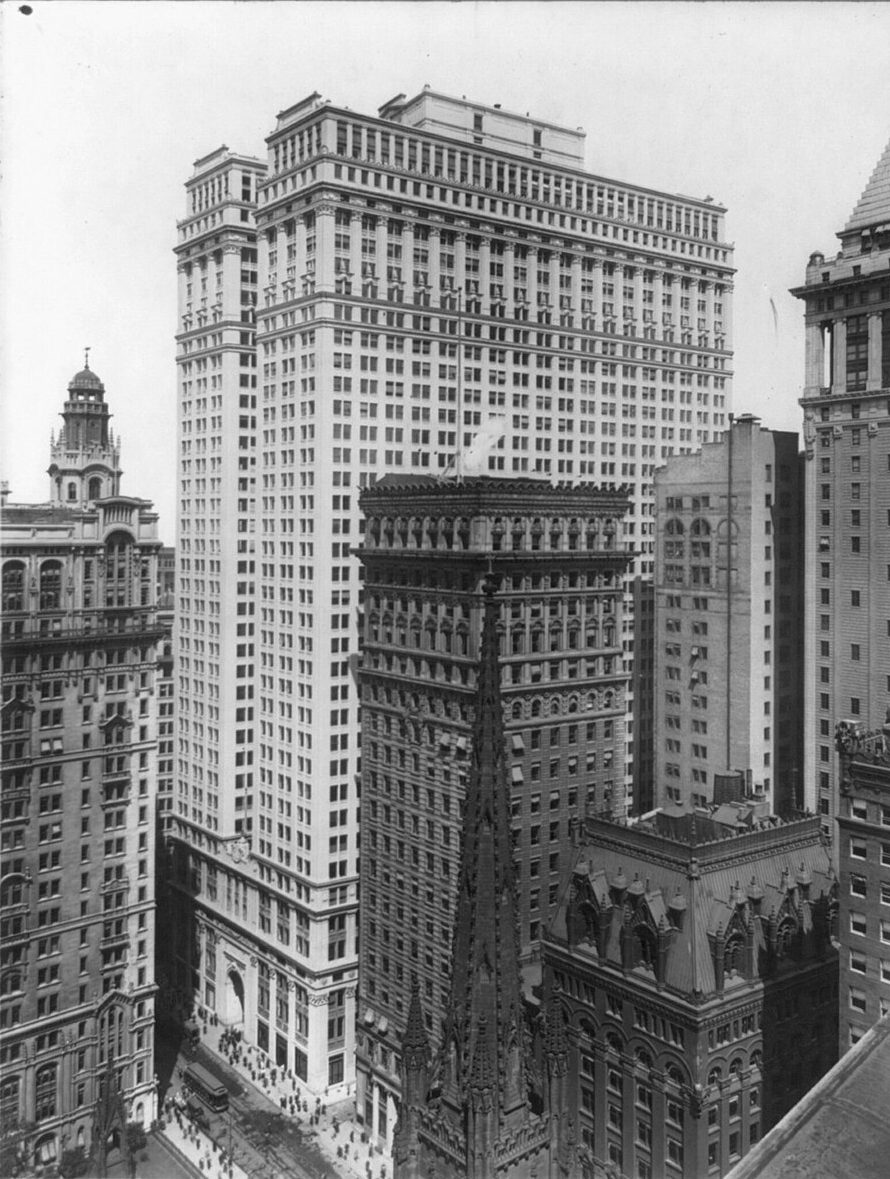 The Equitable Building, a huge flat-topped office block, towering over Trinity Church and its neighbors in lower Manhattan