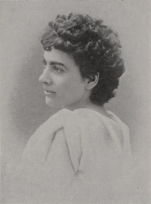 Photograph of Lizzie Magie in profile, with short curly hair and a pale draped top