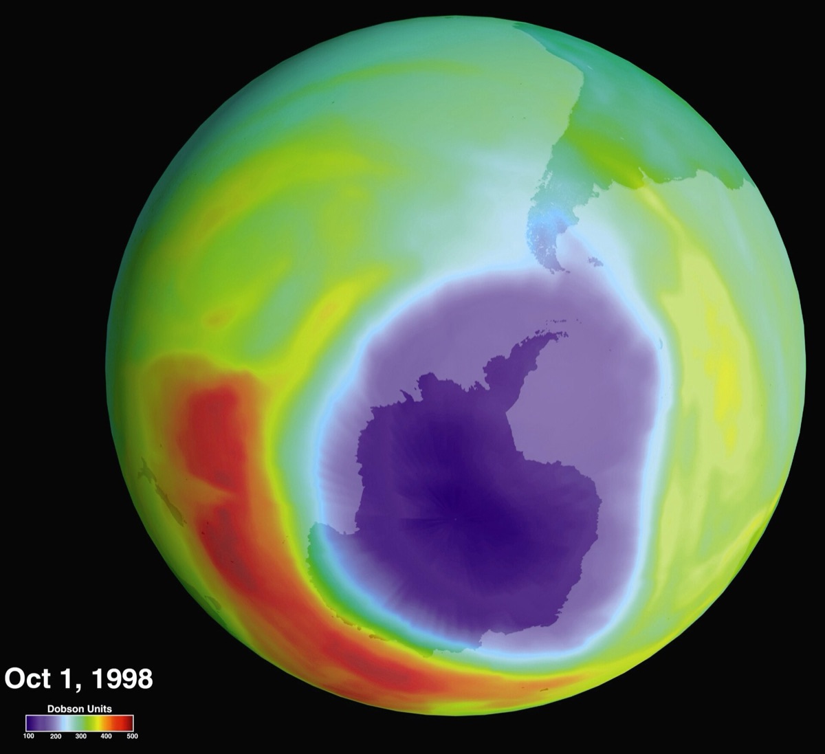 A NASA satellite map of the globe from below, with a large purple ozone hole covering Antarctica