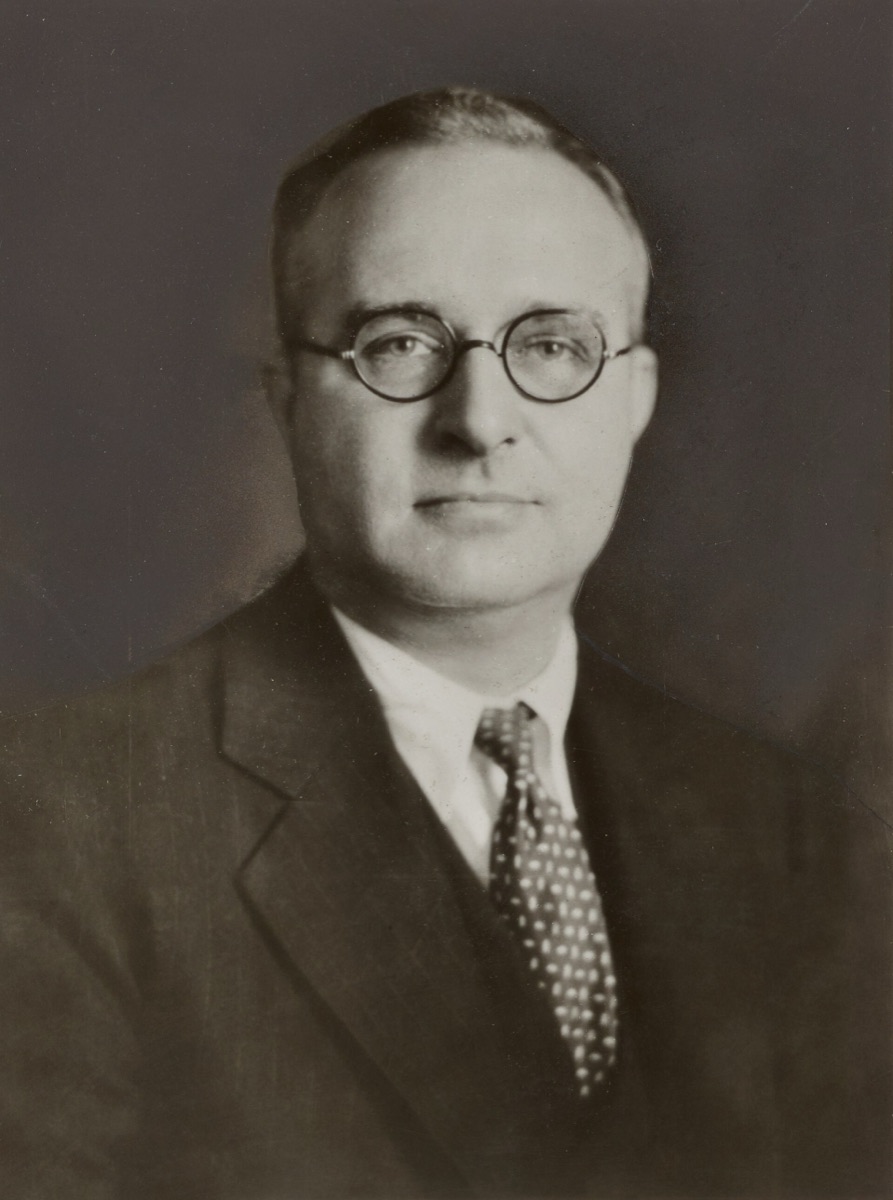 Studio portrait of Thomas Midgley Jr. in round glasses, suit and polka dot tie