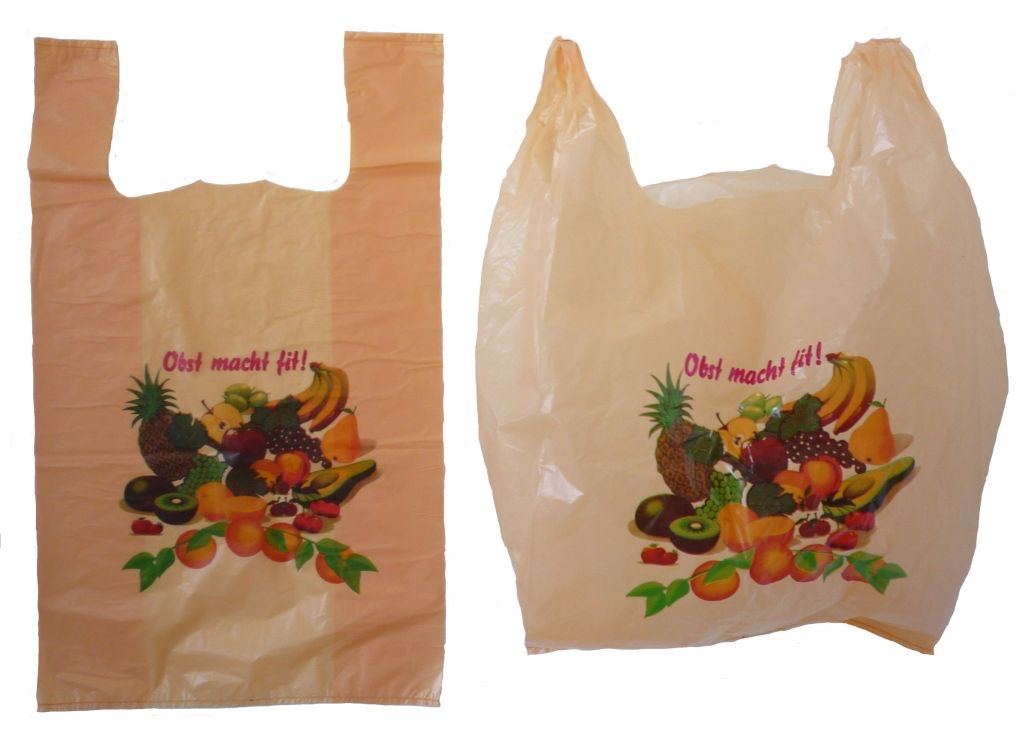 Two thin peach-colored plastic shopping bags with cut-out handles and a printed fruit design, one flat and one open